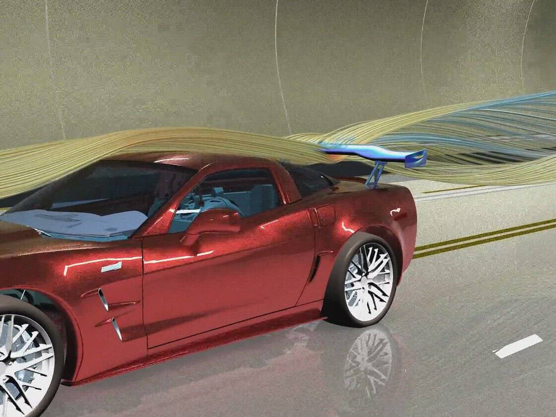Simcenter simulation of a sports car in a wind tunnel: CFD streamlines over the body and the rear wing deflecting under the air load (Siemens image)